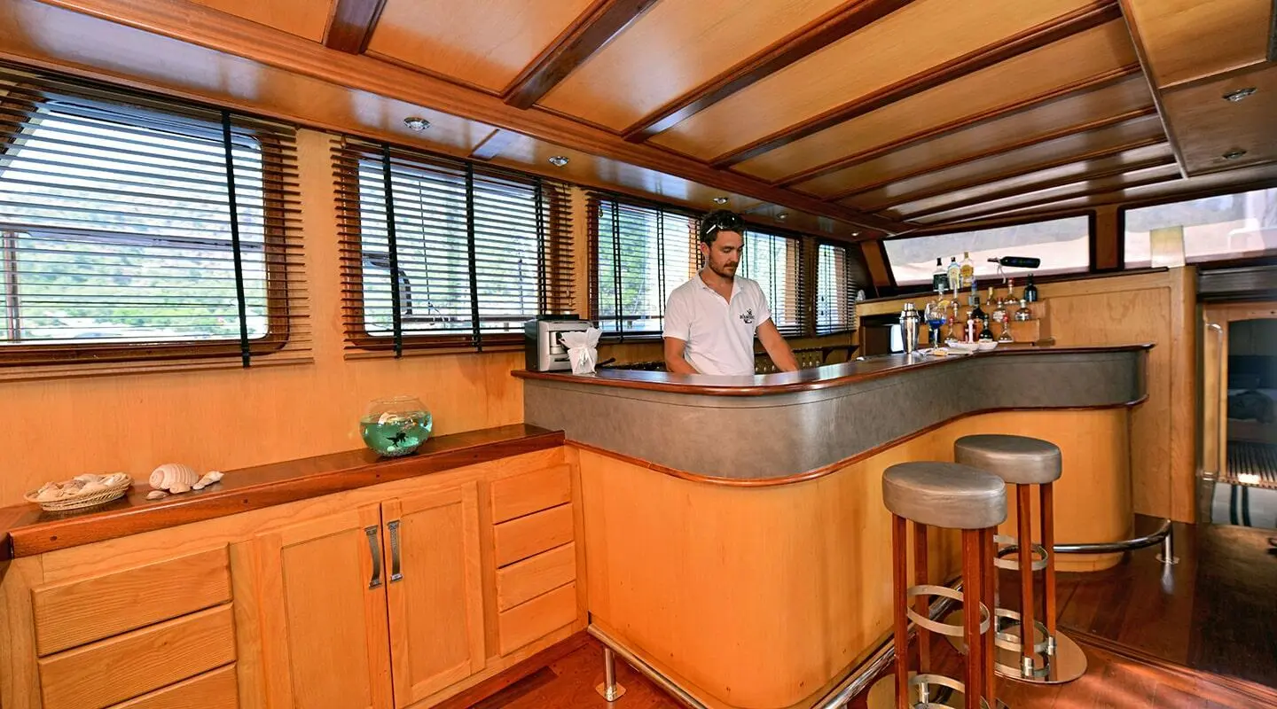 Outdoor yacht interior with wooden cabinetry and a person at a curved bar