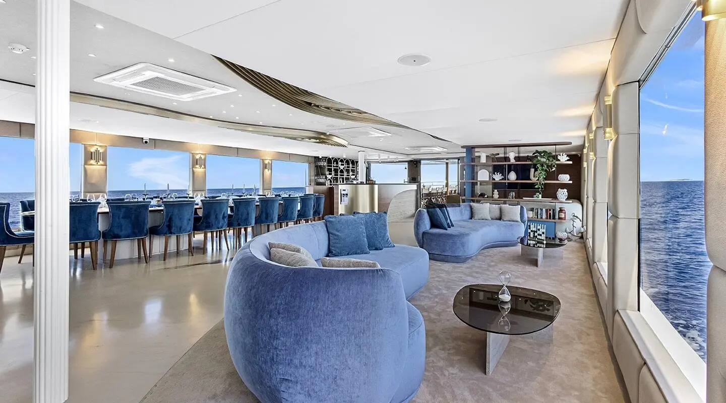 Bella yacht salon with blue rounded chairs and airy seating area outdoors