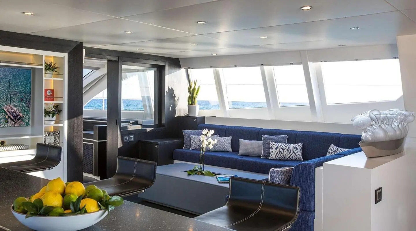 Luxurious yacht Cartouche saloon with blue seating and large windows