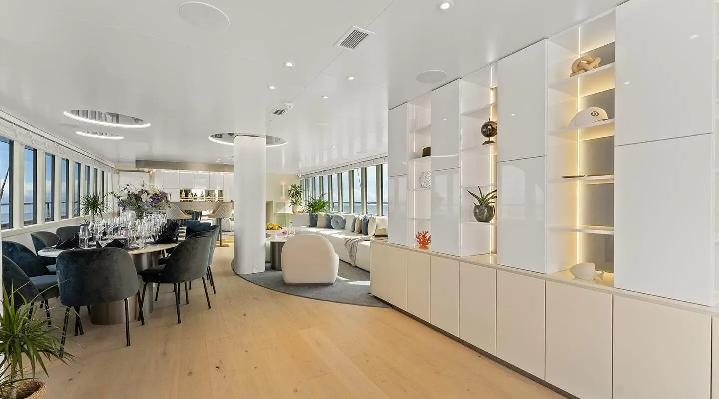 Maxita yacht salon with modern interior, light furniture and large windows