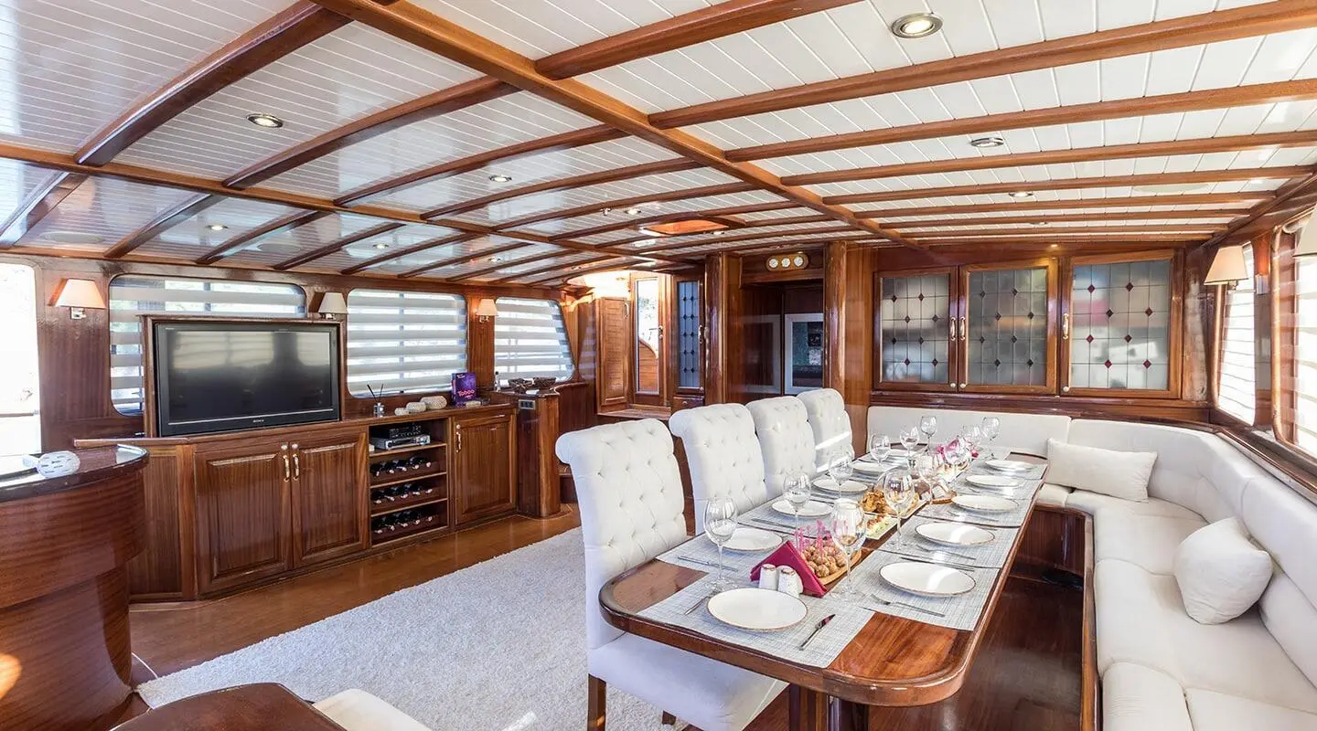 Grace 1 yacht dining area with wooden interior and long table set for meals