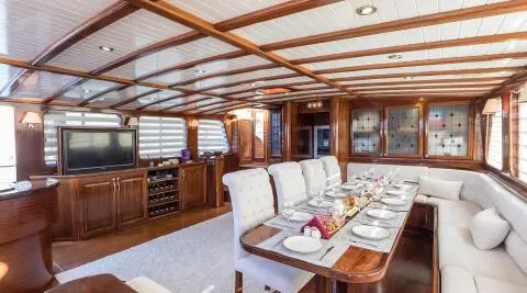 Grace 1 yacht dining area with wooden interior and long table set for meals
