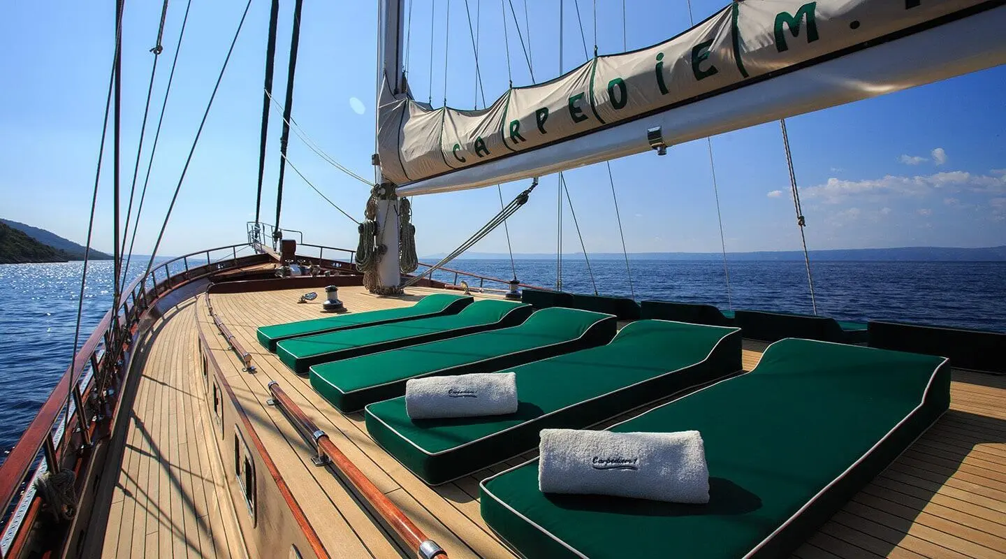 Carpe Diem 7 yacht deck with green seating and wooden rails at sunset