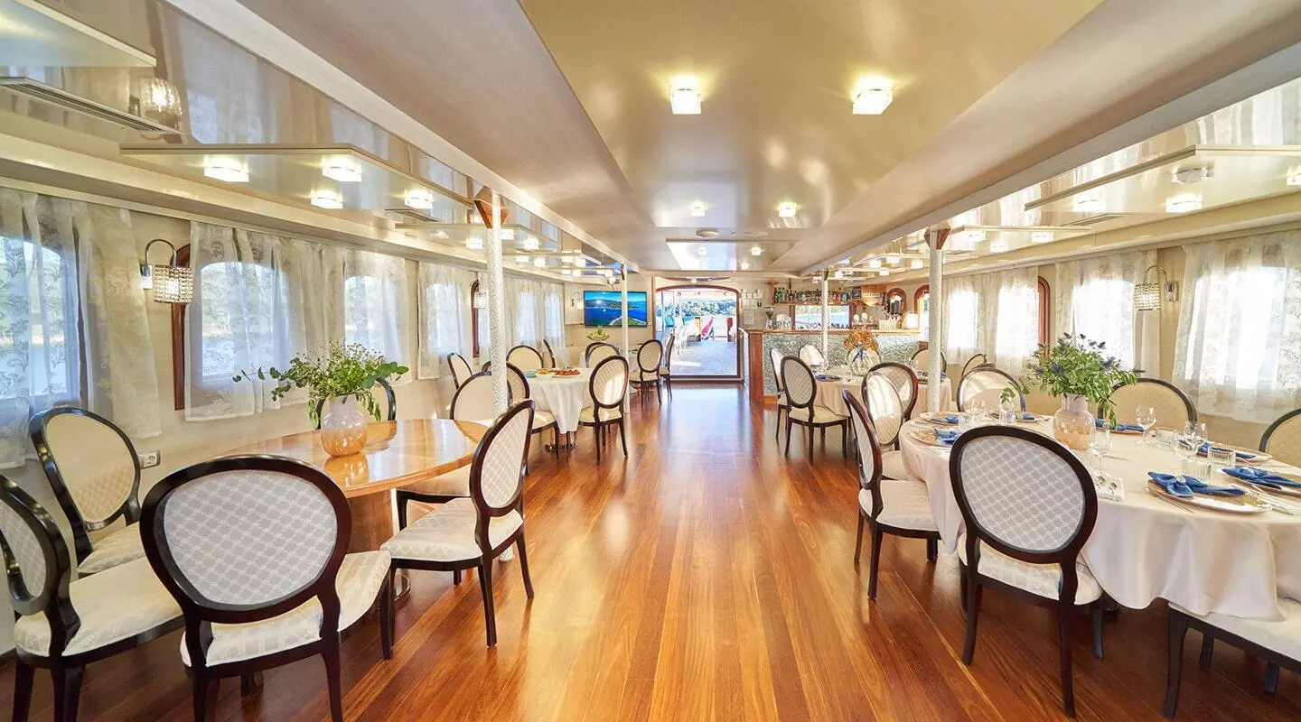 Bright dining hall aboard a yacht with wooden floor and windows