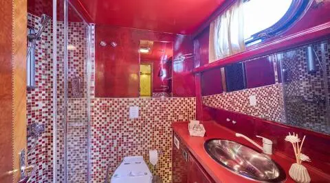 Luxurious red interior of yacht Lotus with ornate seating and pattern walls