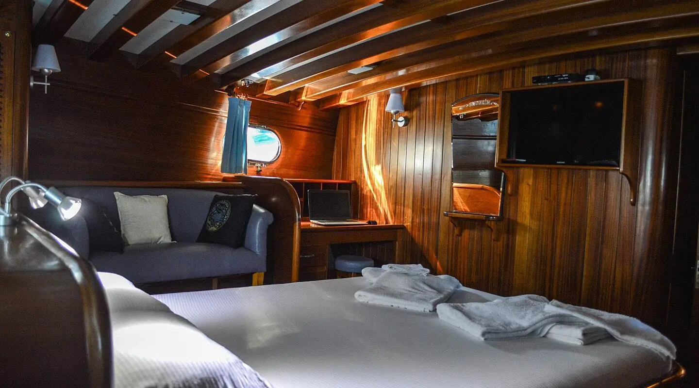 Interior of Enderim A yacht with wooden paneling, bed, and seating.