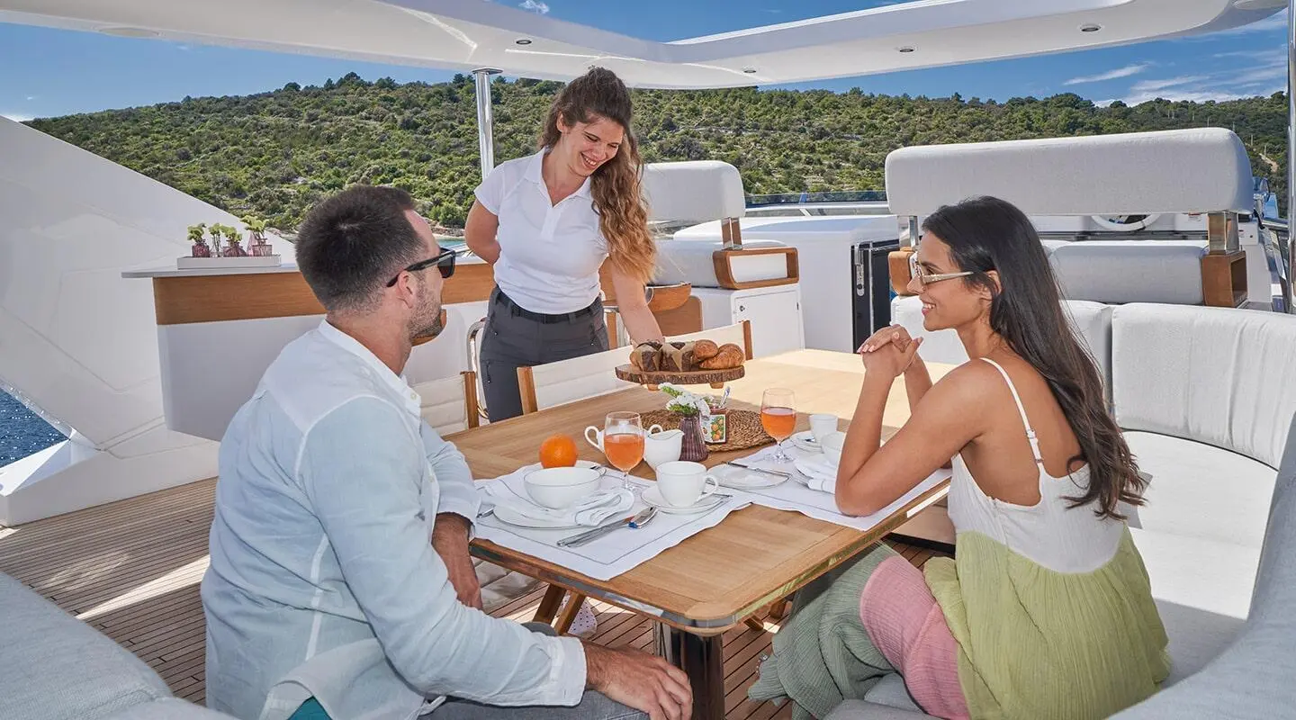 Yacht Aluminia Too on a sunny day with guests dining aboard a deck table