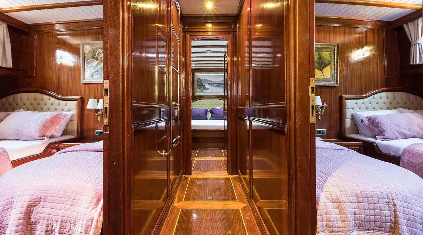 Wood-paneled cabin hallway with two side bedrooms and beds