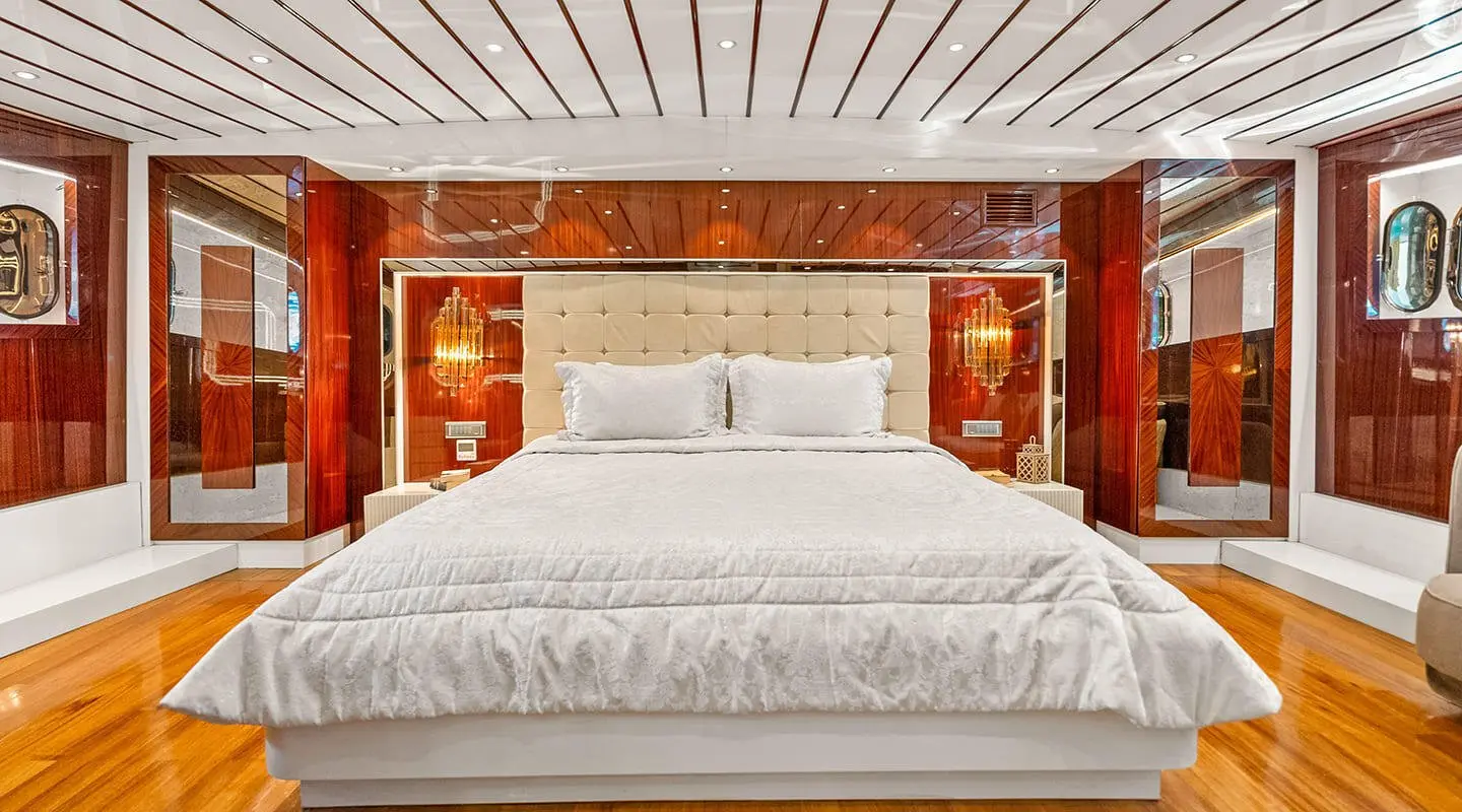 Esma Sultan gulet master cabin with large bed and ornate wood headboard