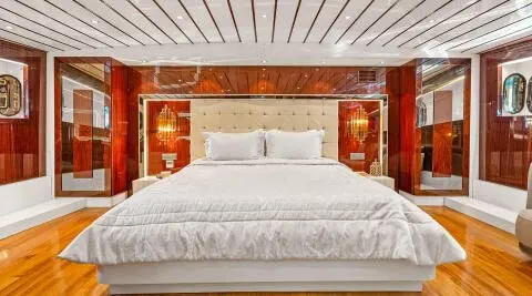 Esma Sultan gulet master cabin with large bed and ornate wood headboard