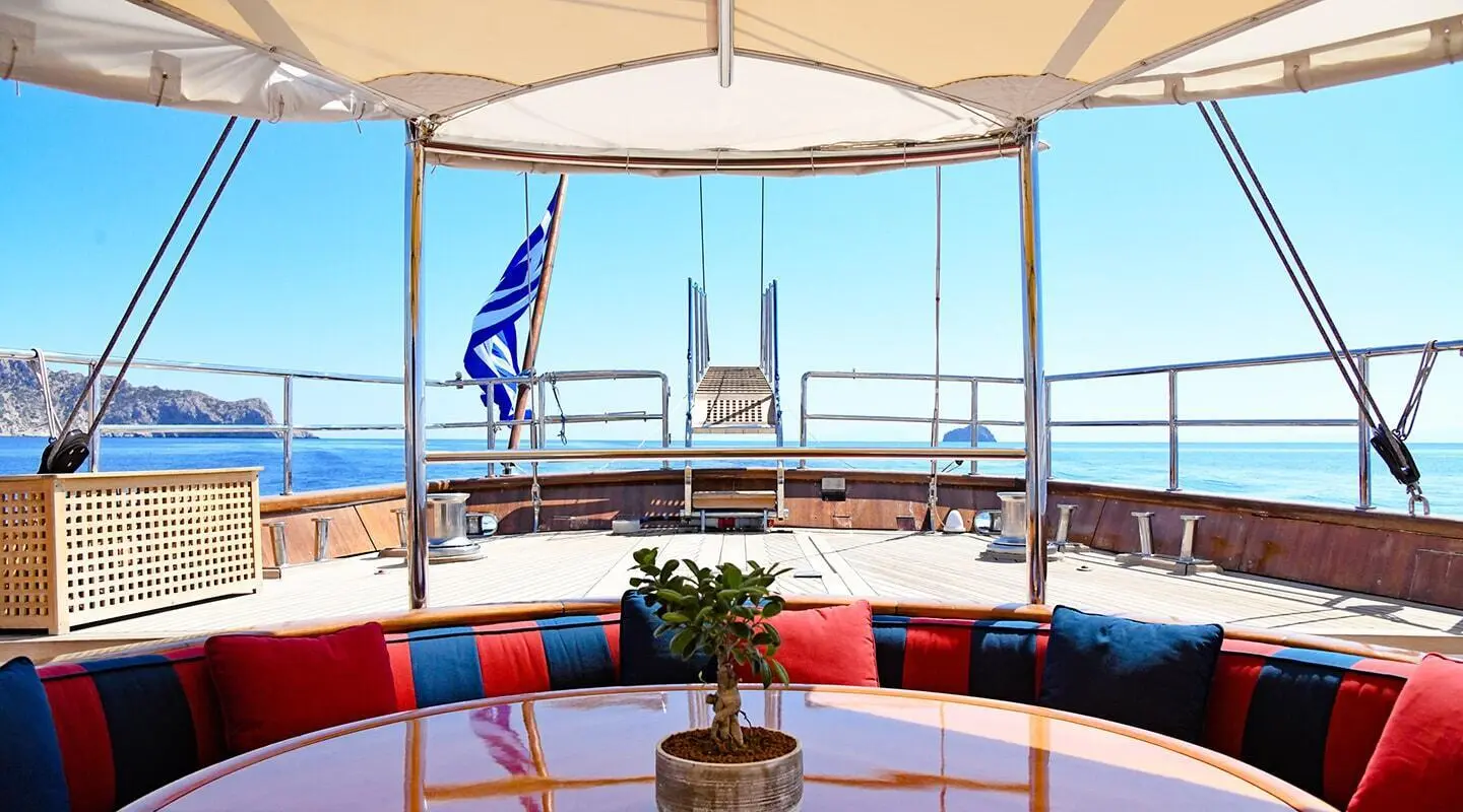 Aft deck of Tamarita yacht with sun loungers and a seating area under a canopy