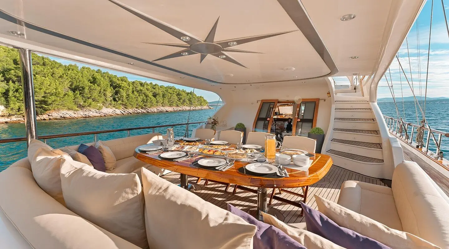Gulet Alessandro I dining area aft deck with table, chairs, and shaded seating