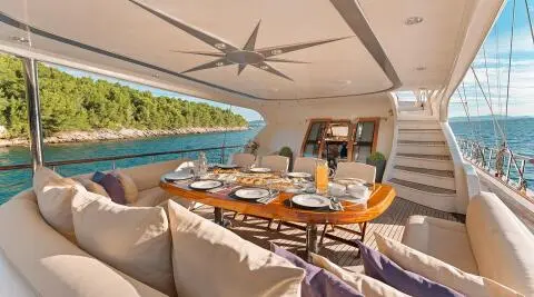 Gulet Alessandro I dining area aft deck with table, chairs, and shaded seating