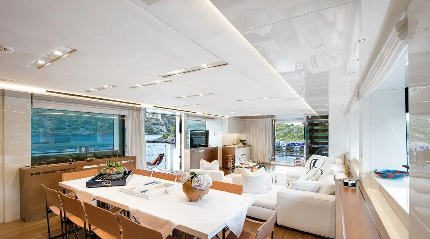 Luxurious yacht interior with a large dining table and white seating area