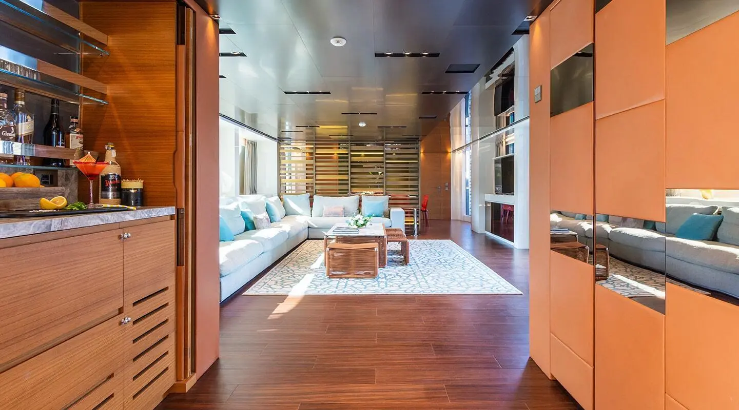 Bright yacht salon with white sofas, central coffee tables and a decorative rug