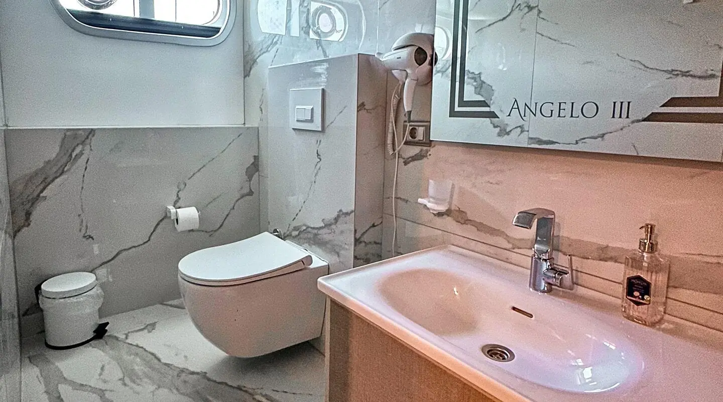 Bathroom aboard Angelo III gulet with sink, mirror, toilet, and shower