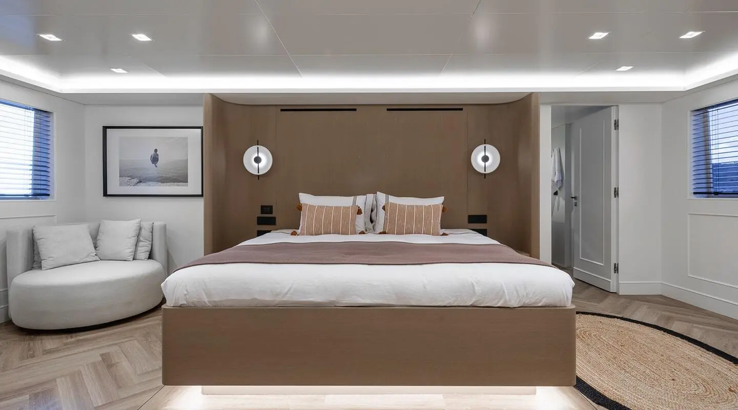 Illusion II yacht bedroom with large bed, brown headboard, bedside lamps