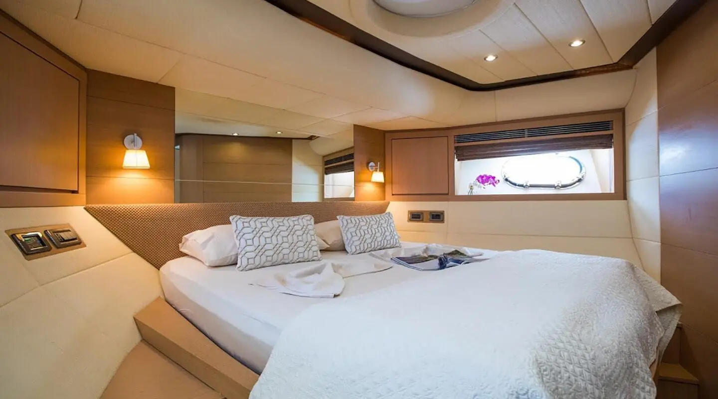 Salt yacht master cabin with large bed, built-in wood panels and ambient lighting