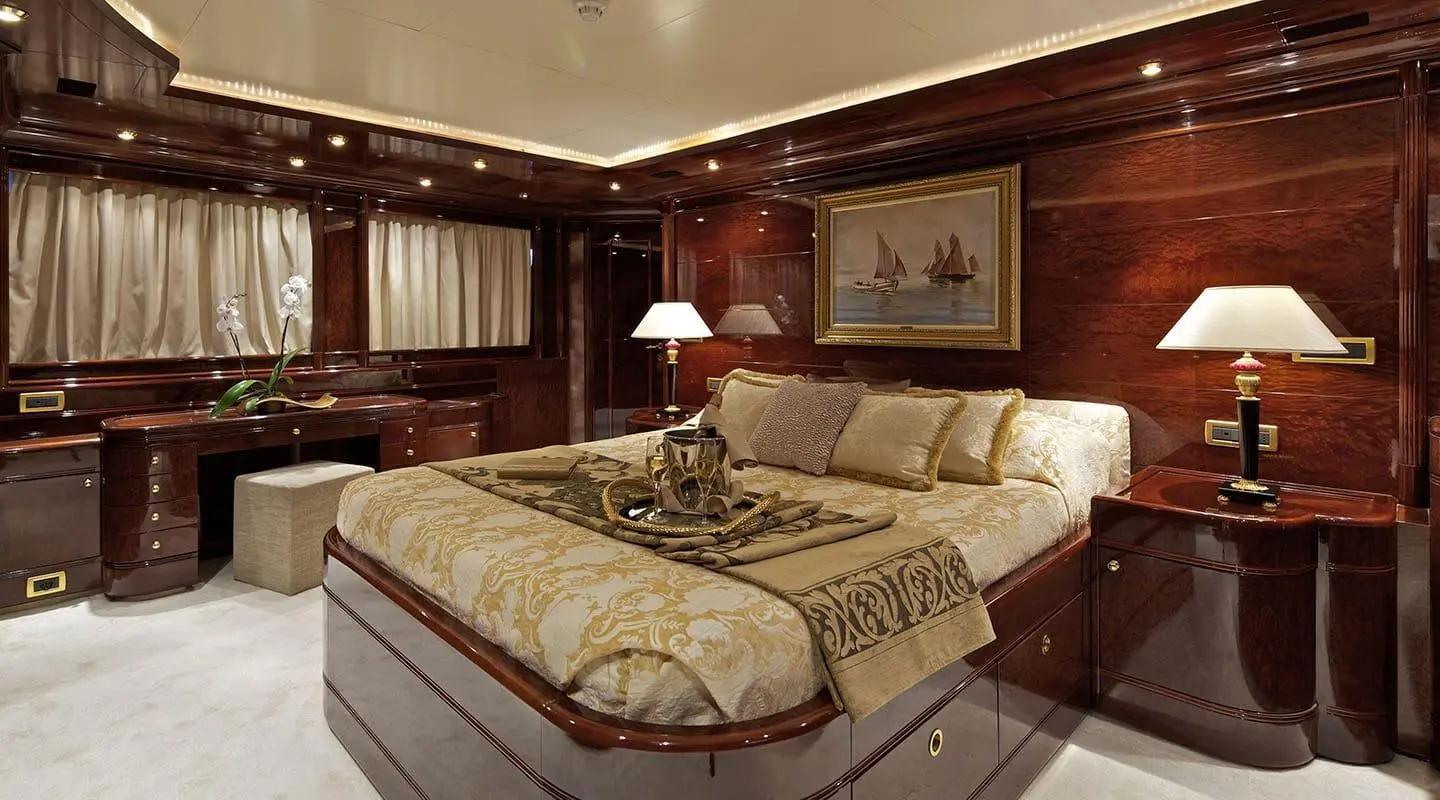 O'Rion yacht cabin with two twin beds, warm wood paneling, and beige bedding.