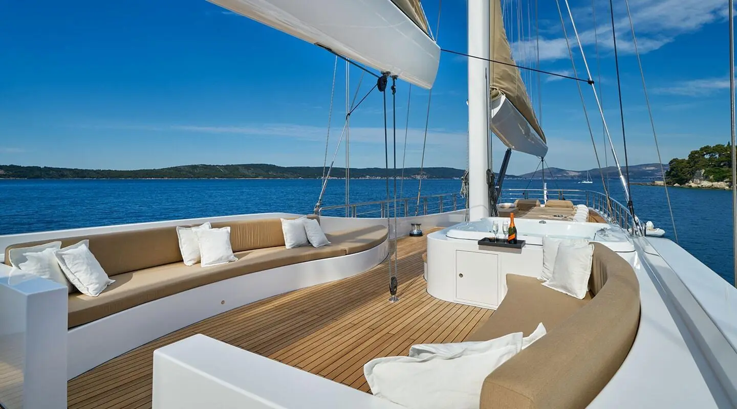 Yacht Acapella flybridge deck with seating and helm under blue sky