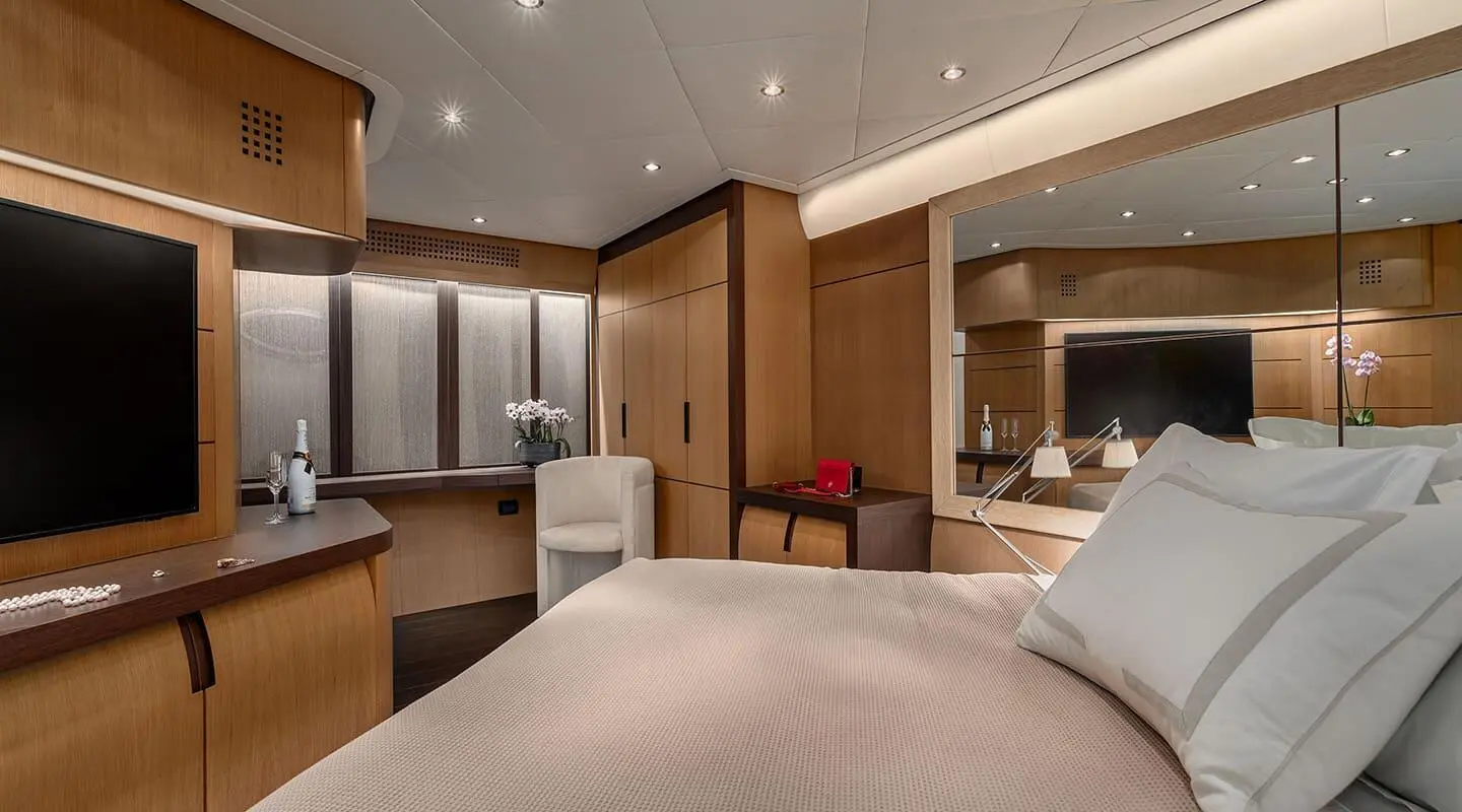 Luxurious yacht One interior cabin with bed, seating, and warm lighting