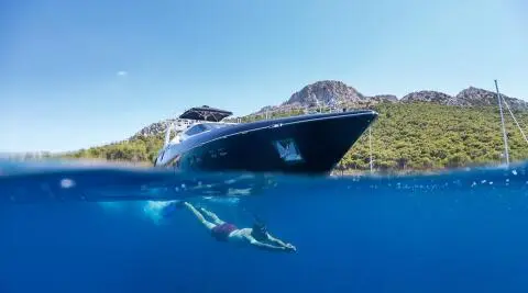 Aquarella luxury yacht anchored at sunset with calm blue water and hills
