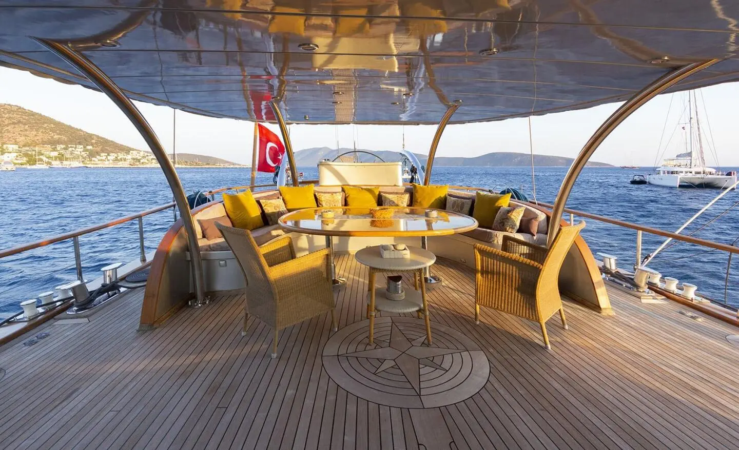 Silver Moon yacht deck with wooden seating under a shaded canopy at sunset