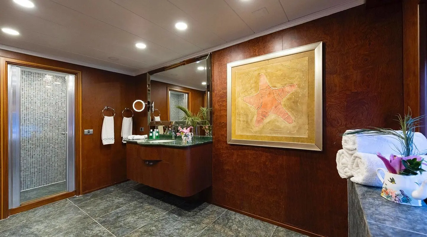 Interior of Ocean Breeze yacht bathroom with wooden cabinets and framed art