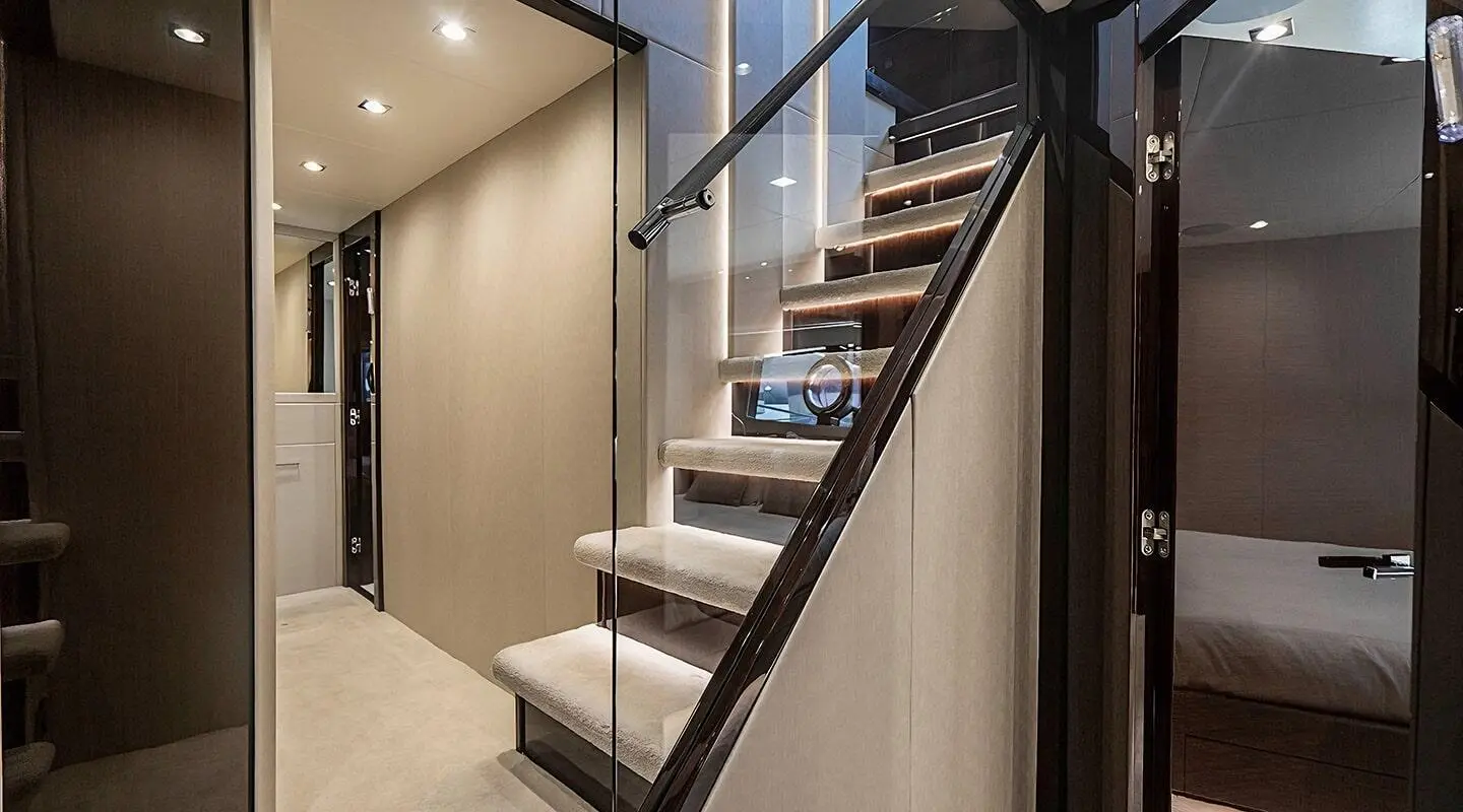 Luxurious interior stairs on Quantum yacht with beige walls and plush carpeting