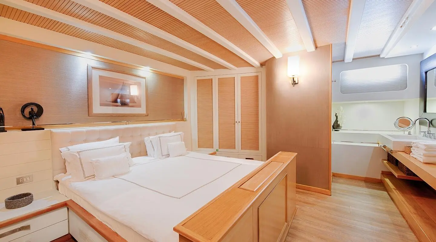 Cobra King yacht interior with wooden ceiling beams, two beds and warm lighting
