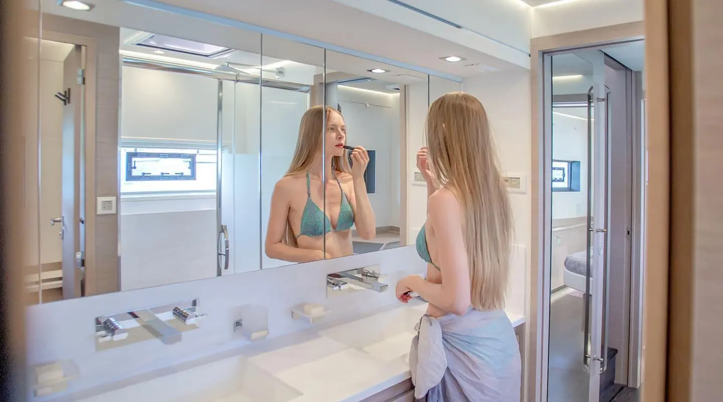 Woman in green bikini applying makeup at a double vanity aboard the 19.69m yacht D2