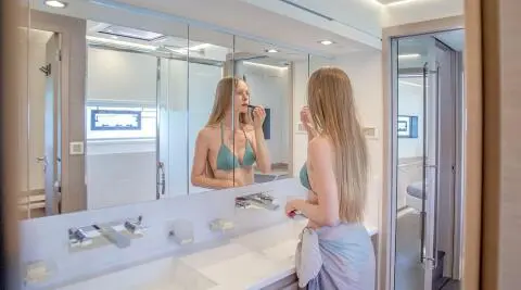 Woman in green bikini applying makeup at a double vanity aboard the 19.69m yacht D2