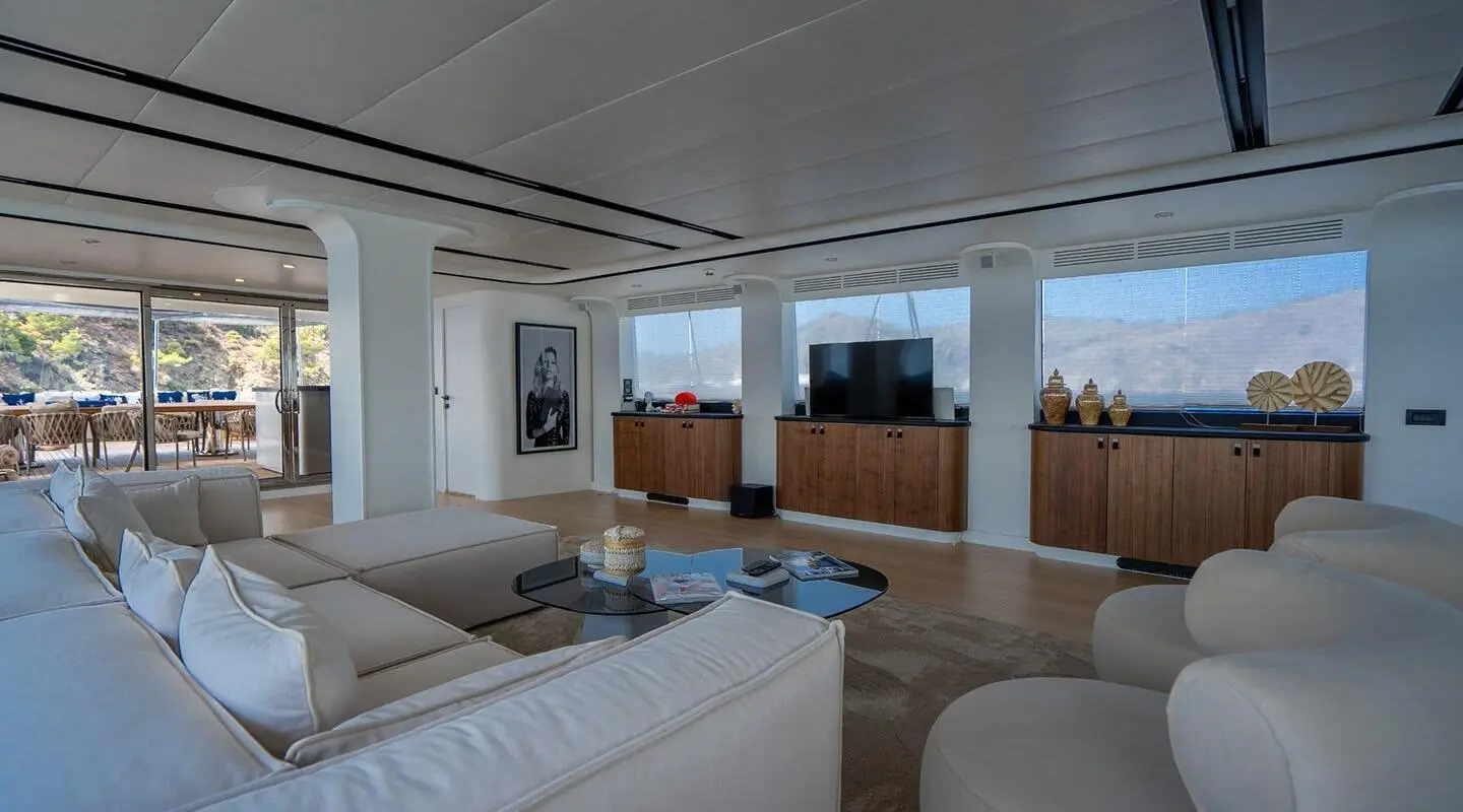 Interior of De Love yacht salon with seating, table, and large windows