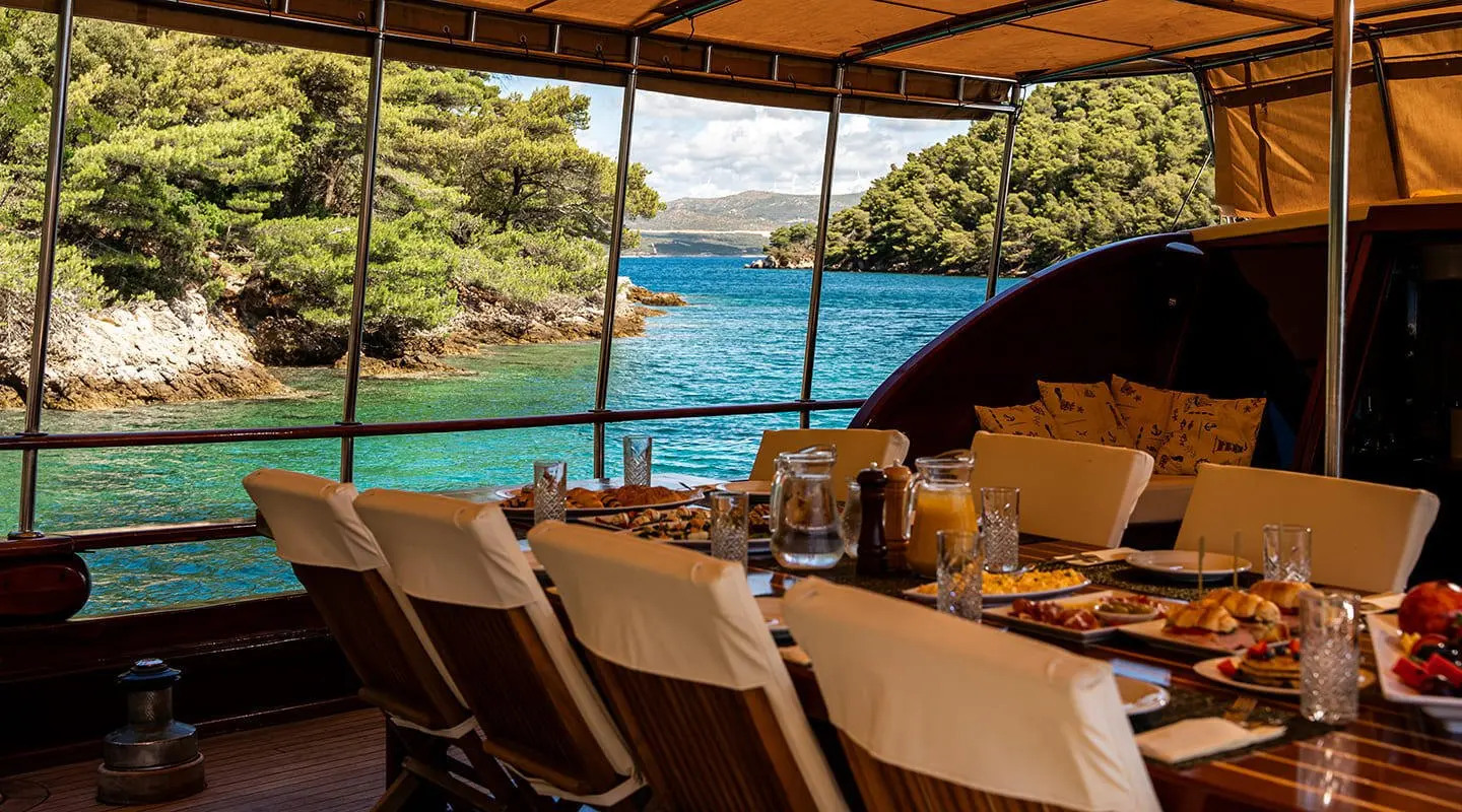 Elegant yacht Eleganza deck seating with sun loungers overlooking turquoise sea at sunset