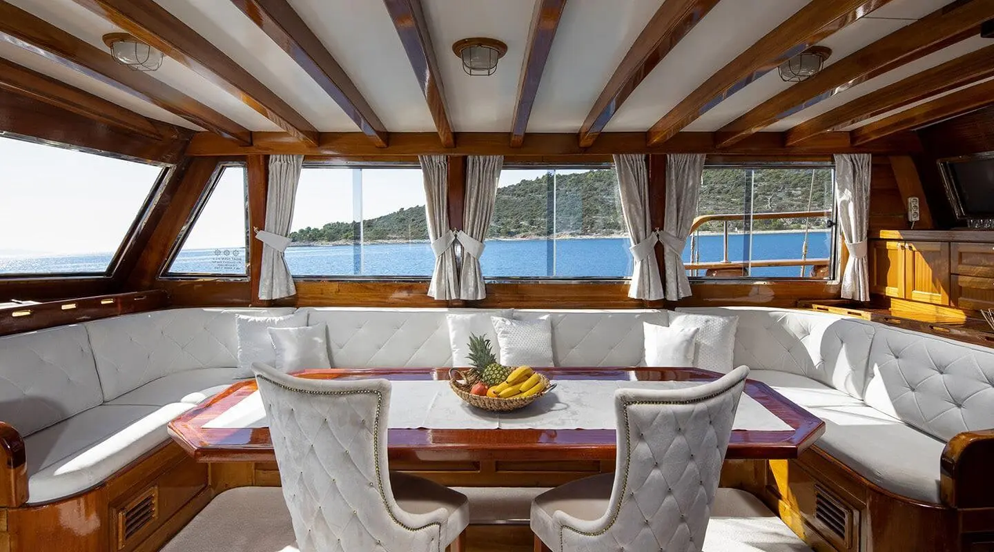 Andi Star luxury yacht deck with wicker chairs, wooden ceiling, and seas at sunset