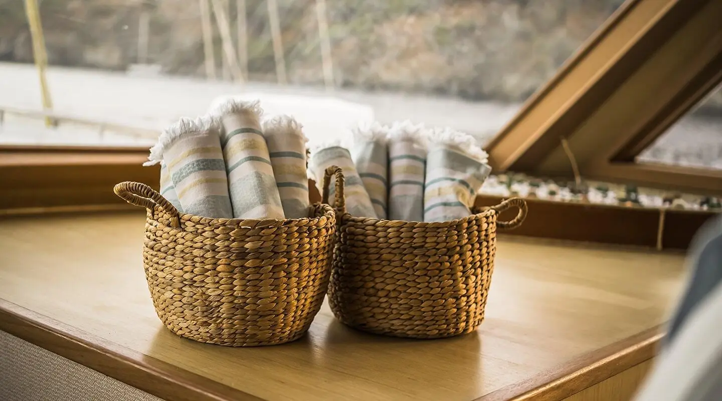 Two woven baskets with striped towels on a yacht interior table