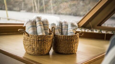Two woven baskets with striped towels on a yacht interior table