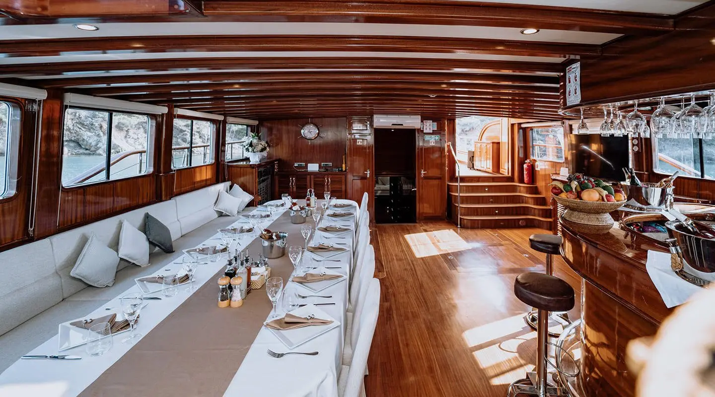 Luxurious yacht interior with polished wood, dining table set for guests