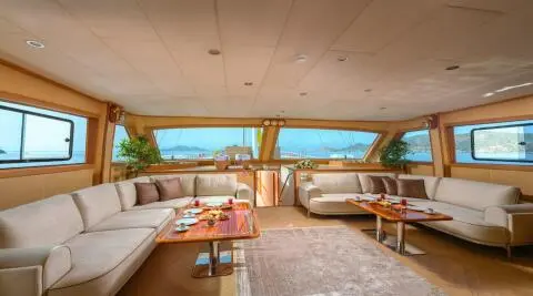 Yacht Belgin Sultan interior deck seating with wooden beams and sunlit view