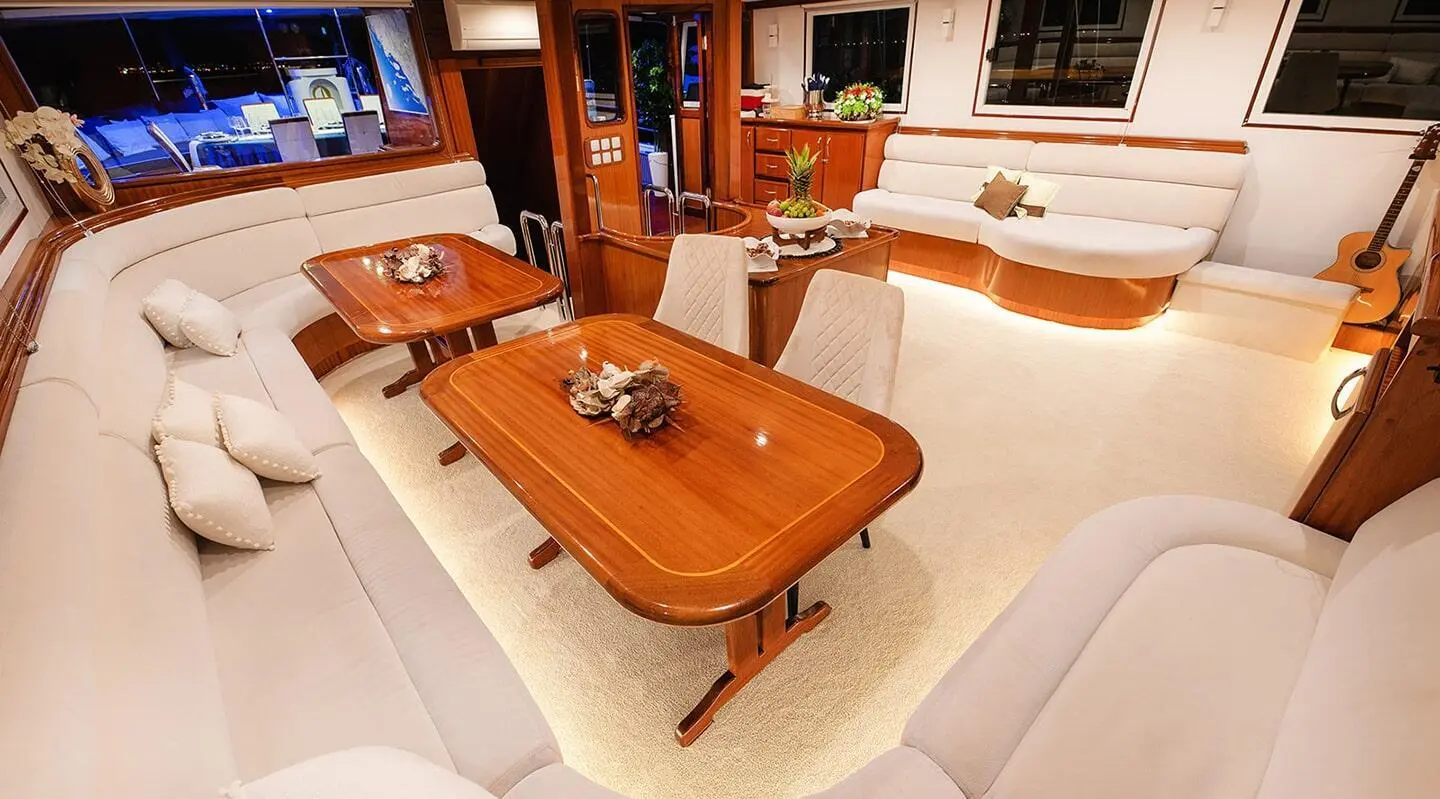 Wooden table with cream seating in an elegant yacht salon interior