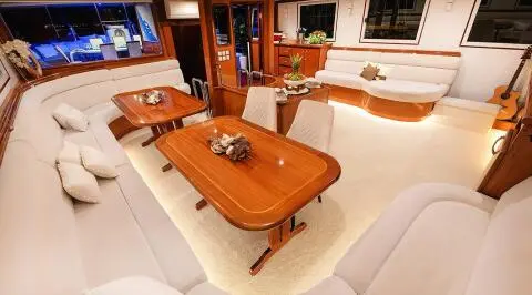 Wooden table with cream seating in an elegant yacht salon interior