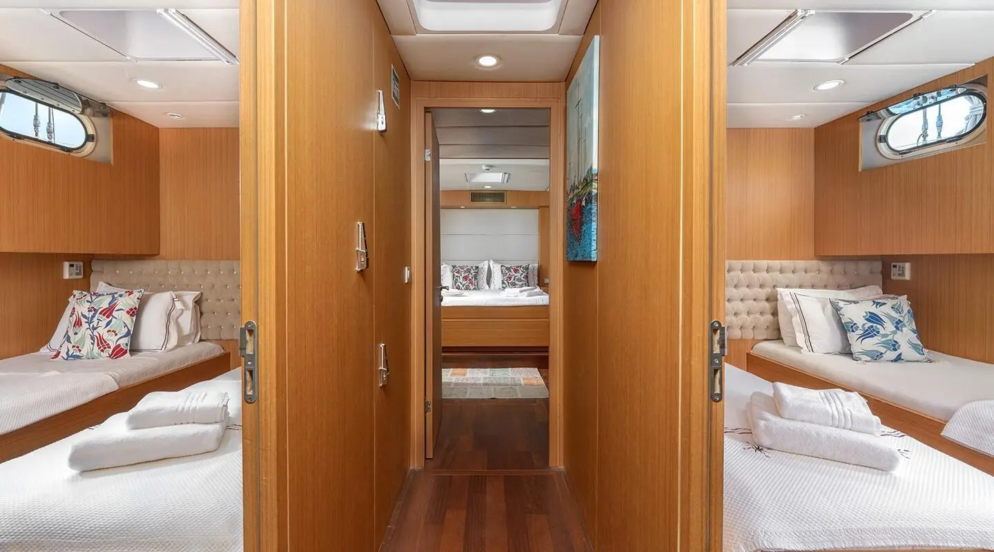 Artemis yacht interior: twin aft cabins with wooden paneling and decorative pillows