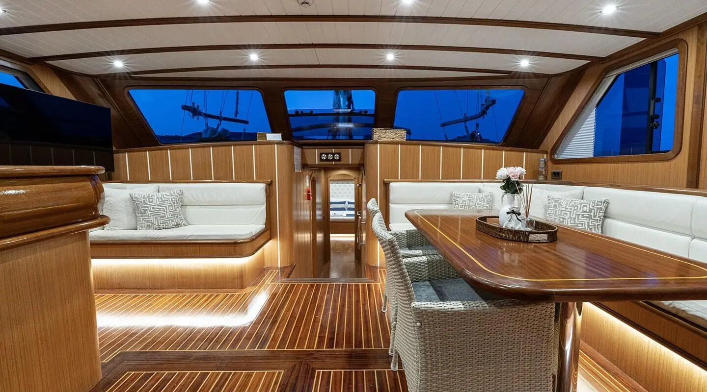 Gozdem The One gulet saloon with wooden deck, seating, and table setup