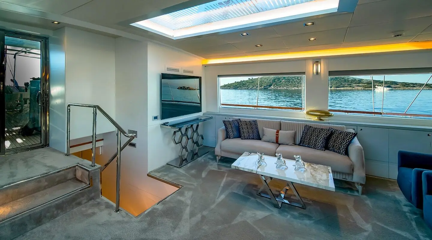 Modern indoor salon with large windows opening to water and shore view