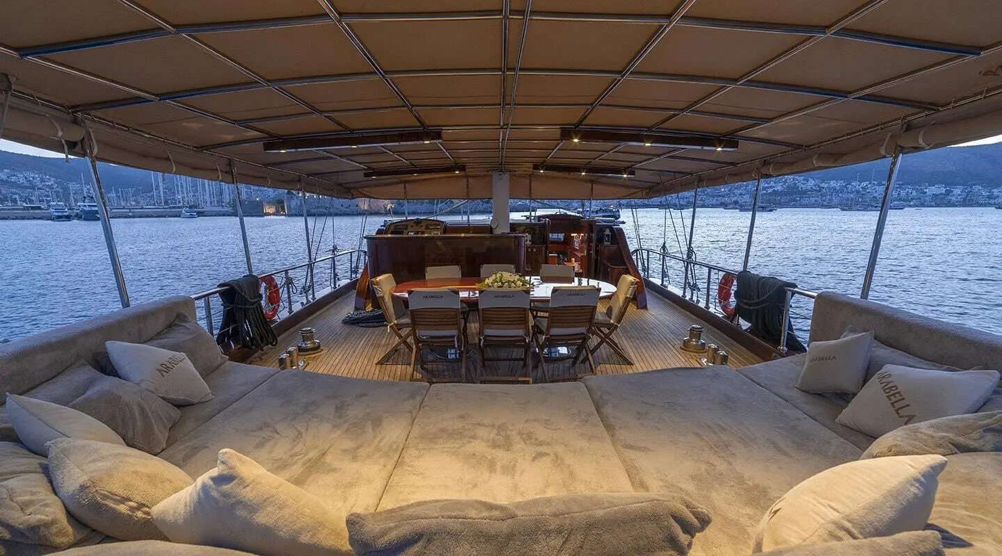 Arabella yacht interior under shaded deck with seating and tables