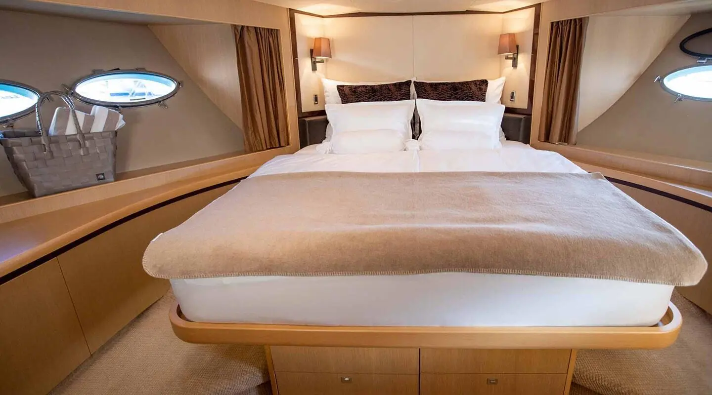 Two white-pillowed VIP cabins with wooden framing and bed in cabin
