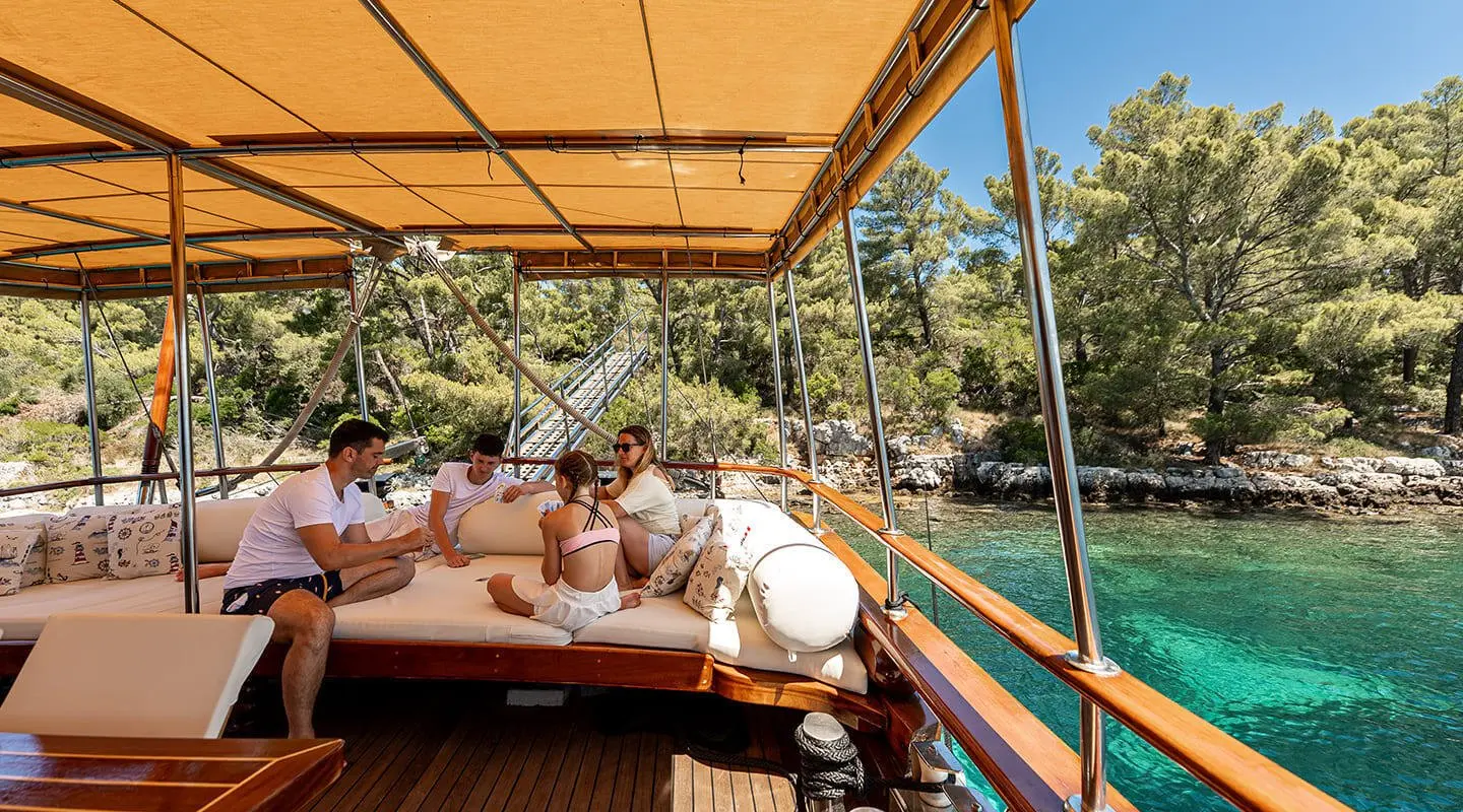 Elegant yacht Eleganza docked at sunset, wooden deck, people on board