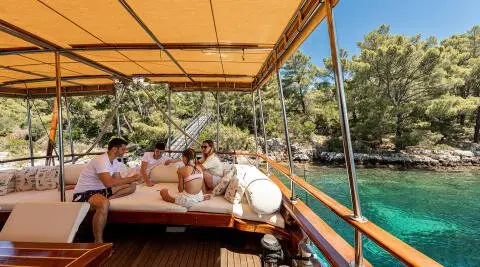 Elegant yacht Eleganza docked at sunset, wooden deck, people on board