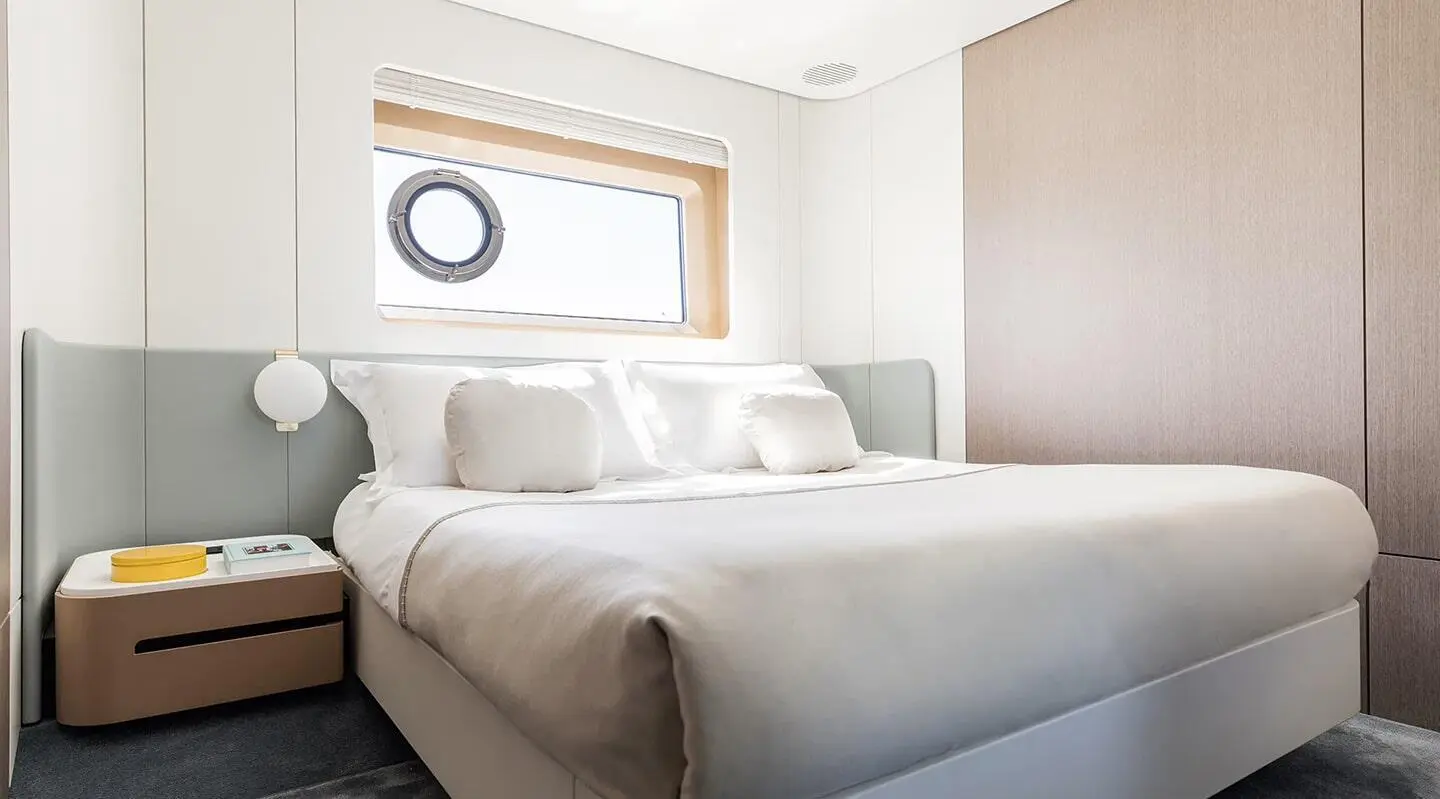 Viva II motor yacht cabin with two large beds, neutral decor, window view