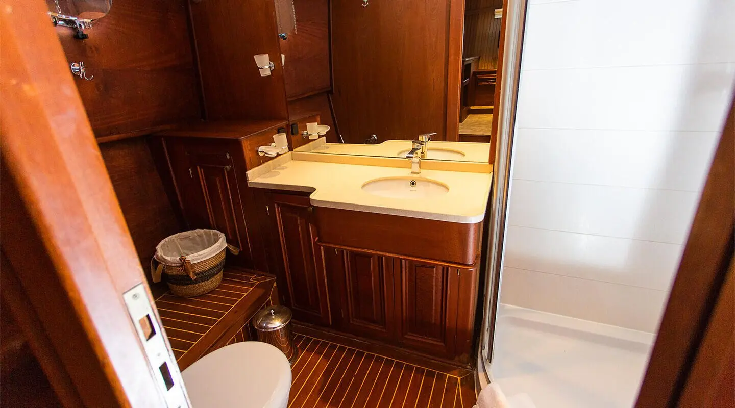 Dolce Vita yacht interior with polished wood cabinet, sink, and warm lighting
